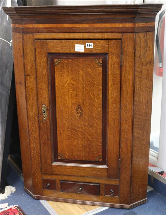 A late 18th century oak and mahogany banded hanging corner cupboard W.76cm